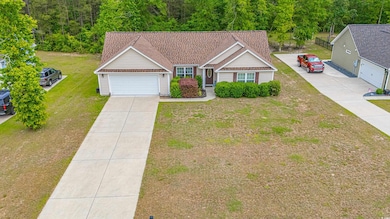 Ranch-style house with an attached garage, a front yard, and concrete driveway