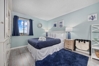 Bedroom featuring a textured ceiling, wood finishe