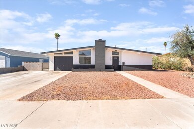 Mid-century home featuring stucco siding, driveway