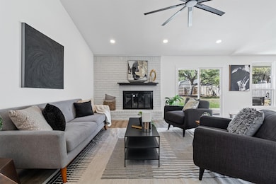 Living area with a fireplace, wood finished floors, recessed lighting, and ceiling fan