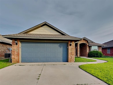 Single story home featuring concrete driveway, a garage, brick siding, and a front yard