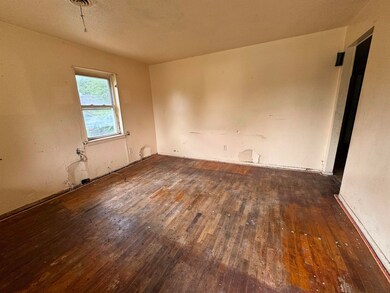 Spare room featuring a textured ceiling and wood-t