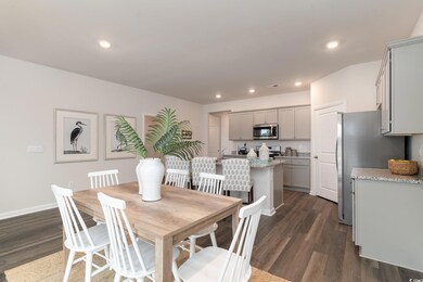 Dining room with dark wood finished floors, recessed lighting, and baseboards