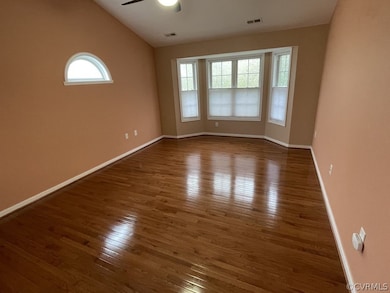 Empty room with ceiling fan, vaulted ceiling, and