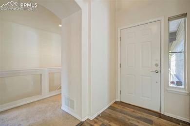 Foyer featuring arched walkways and wood finished floors