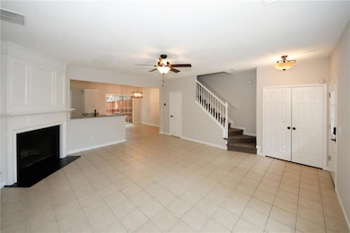Unfurnished living room with a fireplace with raised hearth, stairway, a chandelier, and light tile patterned flooring