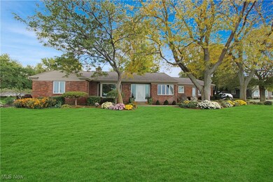Ranch-style house with a front yard, brick siding, and a chimney
