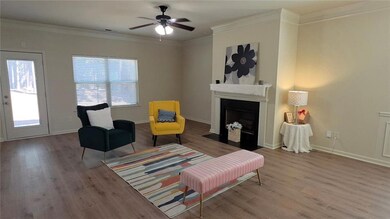 Living area with ornamental molding, wood finished floors, a fireplace with flush hearth, and a ceiling fan