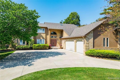 View of front of home featuring concrete driveway, a shingled roof, an attached garage, and brick siding