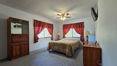 Spacious bedroom with large windows, ceiling fan, and lots of natural light. If you need a king size bed, just place the bed on the other wall for a comfortable fit and flexible layout options.