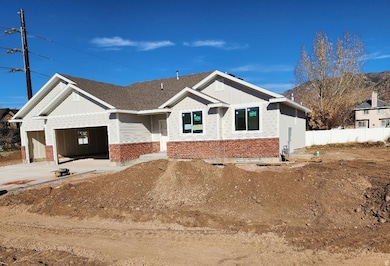 View of front facade with board and batten siding, brick siding, concrete driveway, and an attached garage