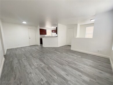Unfurnished living room featuring baseboards and wood finished floors
