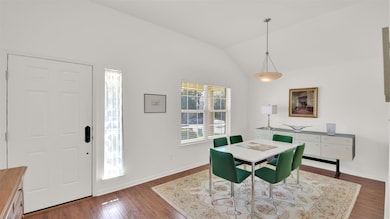 Dining space featuring vaulted ceiling and dark w