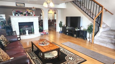 Living room with arched walkways, wood finished f
