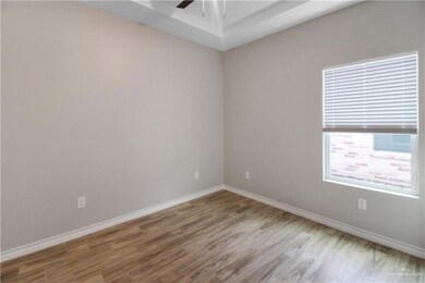 Unfurnished room with wood finished floors, a ceiling fan, and baseboards