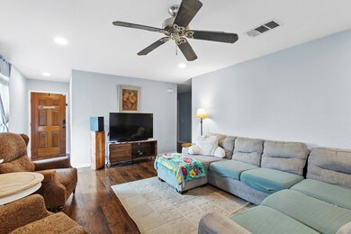 Living room with dark wood-type flooring, recessed lighting, and ceiling fan