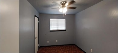Spare room with a ceiling fan, a textured ceiling,