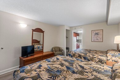 Bedroom with a textured ceiling, hardwood / wood-s