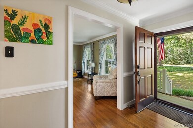 Entryway featuring ornamental molding and dark woo