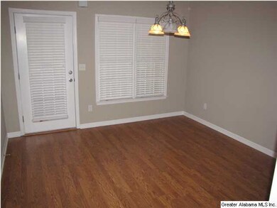 Separate dining room with gleaming hardwoods.