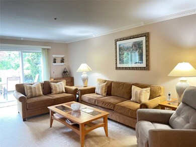 Living room featuring crown molding and light colored carpet