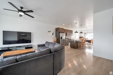 Living area with light wood-style floors, recessed lighting, and ceiling fan