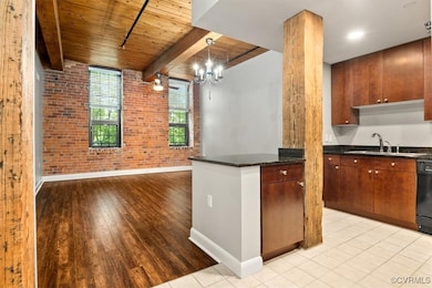 Kitchen with brick wall, a sink, baseboards, wood