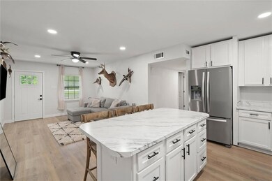 Kitchen featuring stainless steel refrigerator with ice dispenser, a ceiling fan, recessed lighting, light wood-style flooring, and white cabinetry