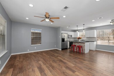 The home has an open living and dining space, with freshly painted walls, and gorgeous vinyl plank flooring.