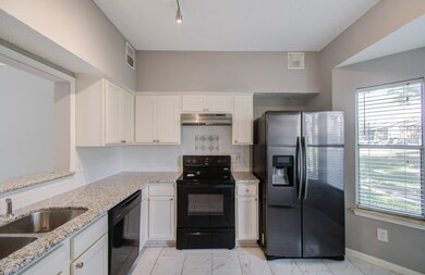 This is a well-lit, modern kitchen featuring stain
