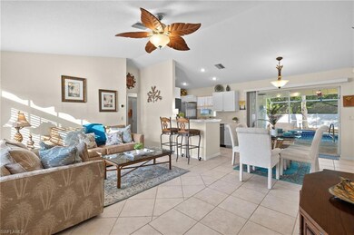 Tiled living room with ceiling fan and lofted ceil