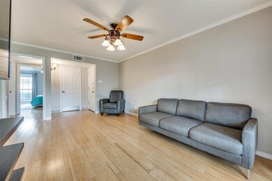 Living room featuring ornamental molding, light wood-type flooring, and ceiling fan