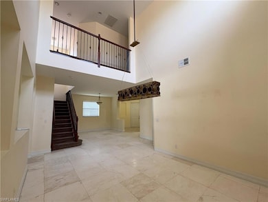 Stairway featuring a towering ceiling and baseboards