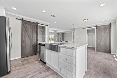 Kitchen with white cabinetry, light hardwood / woo