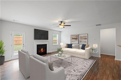 Living area with visible vents, a ceiling fan, woo