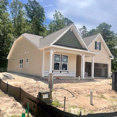 View of front facade with covered porch, roof with shingles, and a garage
