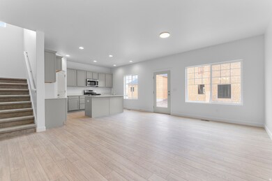 Kitchen with gray cabinets, open floor plan, light countertops, recessed lighting, and light wood finished floors