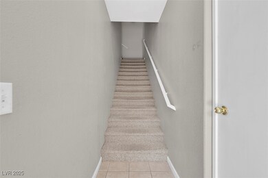 Stairs with tile patterned floors and baseboards