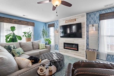Living room with ceiling fan, a wealth of natural 
