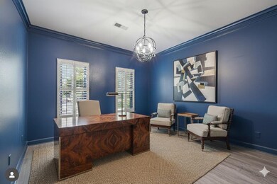 Office area featuring ornamental molding, wood finished floors, and a chandelier