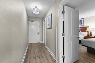 Hallway featuring light wood finished floors, base