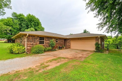 Ranch-style home with a garage, driveway, and brick siding