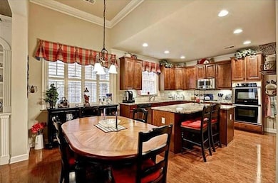 Dining space with ornamental molding, wood finished floors, and recessed lighting