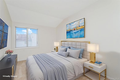 Bedroom featuring light carpet and lofted ceiling