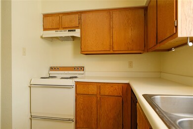 Kitchen featuring a sink, light countertops, under