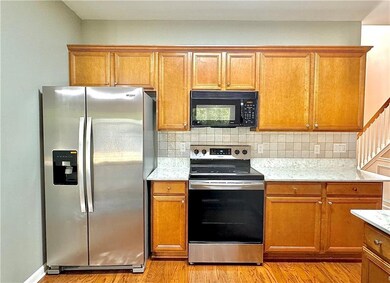 Kitchen featuring appliances with stainless steel finishes, light wood finished floors, and tasteful backsplash
