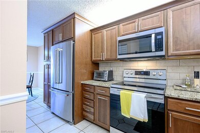 Kitchen featuring tasteful backsplash, light stone