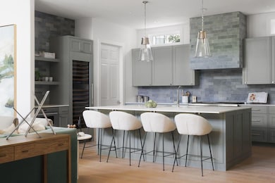 Kitchen with light wood-style flooring, backsplas