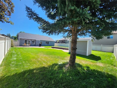 Back of property featuring a fenced backyard, a patio area, and a shed