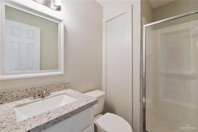 Bathroom featuring walk in shower, toilet, and vanity